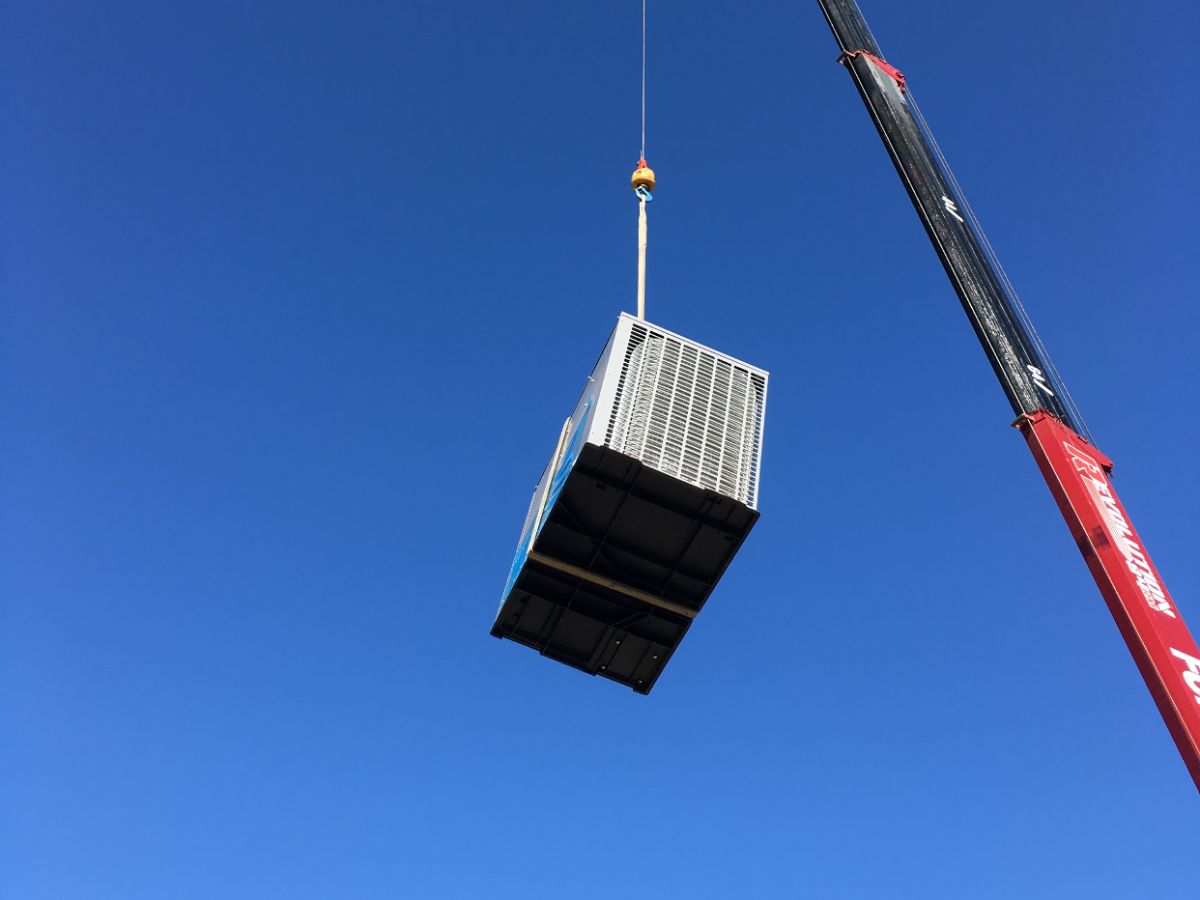 HomeTown Air crane lifting a new rooftop AC unit during a Mesa, AZ installation